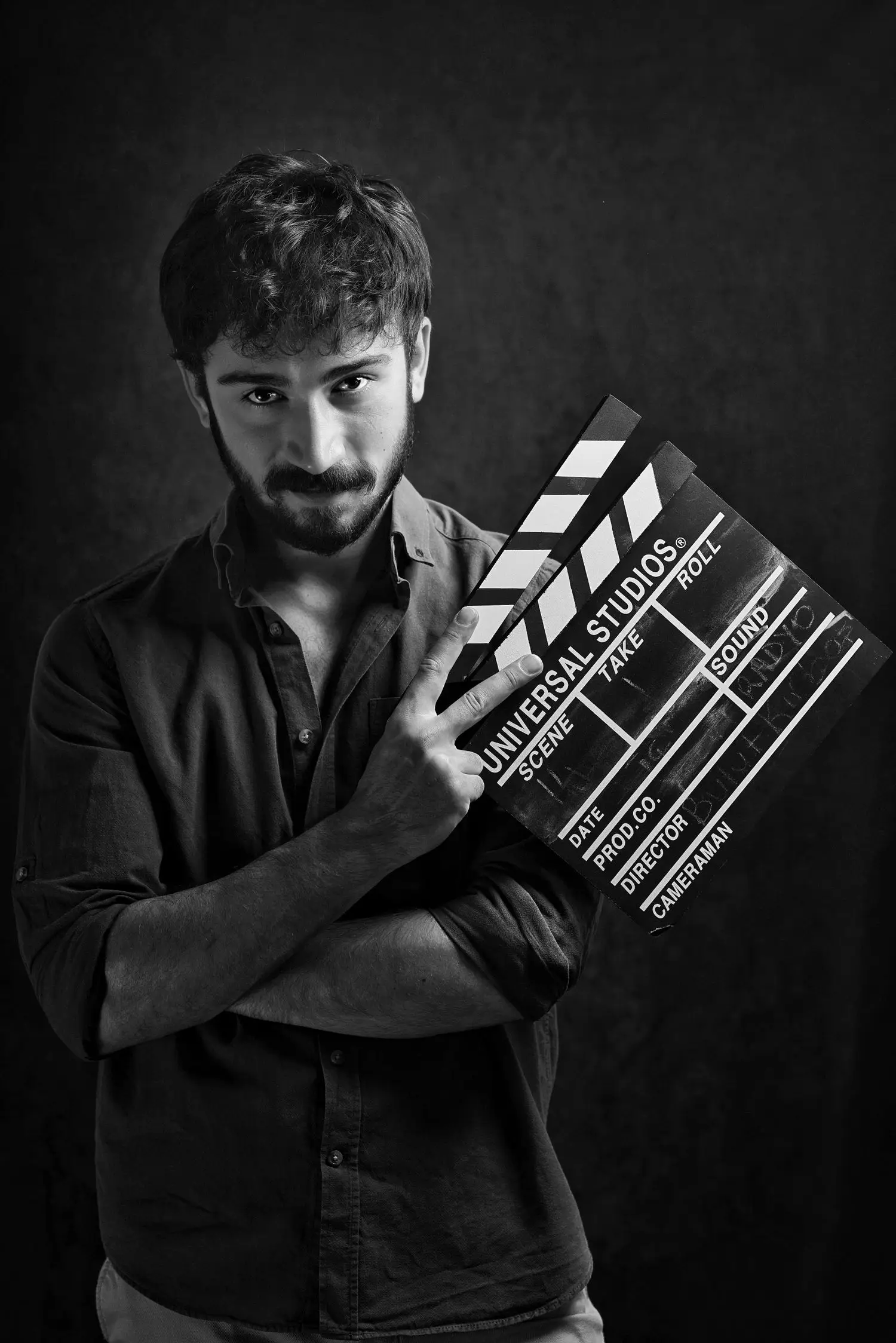 Filmmaker holding a clapperboard in a dark studio