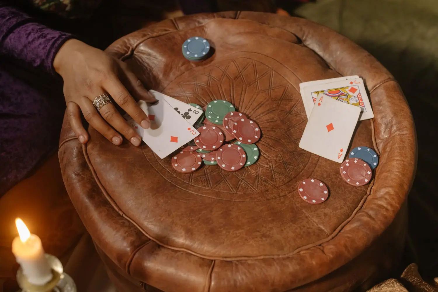 Cards and chips arranged on a round table under warm light